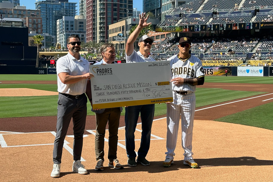 San Diego Rescue Mission CEO Donnie Dee receiving a large check at Petco Park