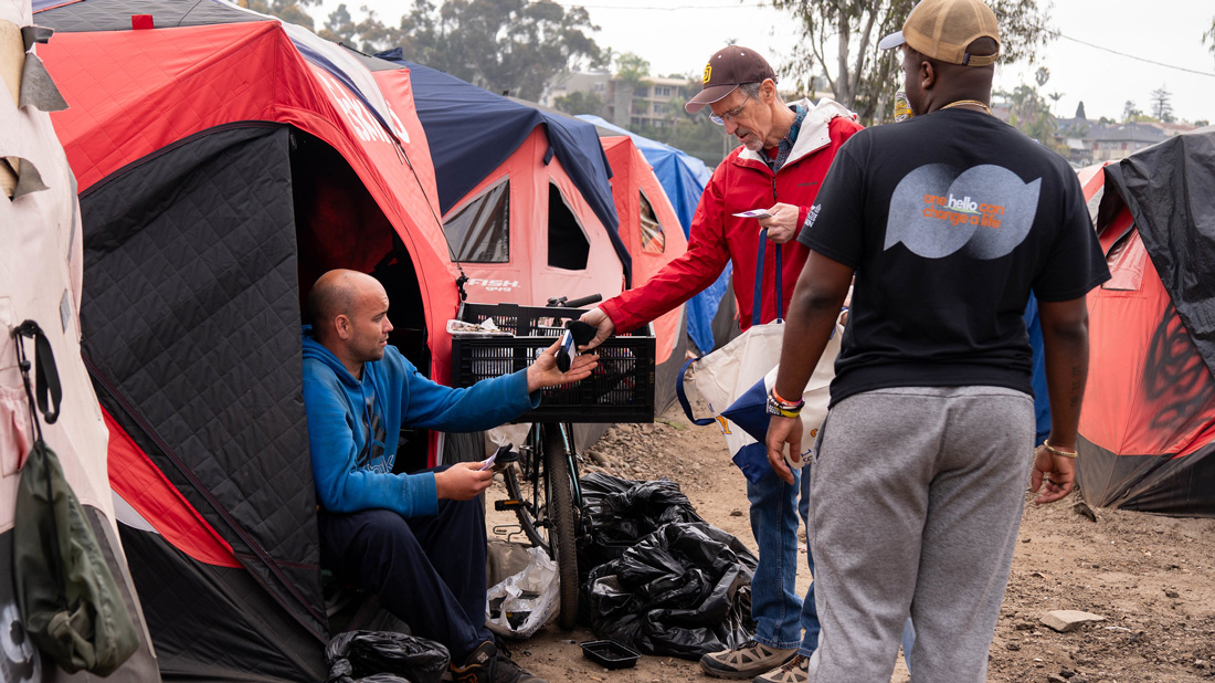 Outreach workers with man in a tent