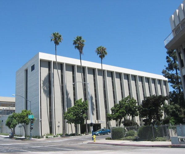 San Diego Rescue Mission homeless shelter white building with palm trees and blue sky in Downtown San Diego