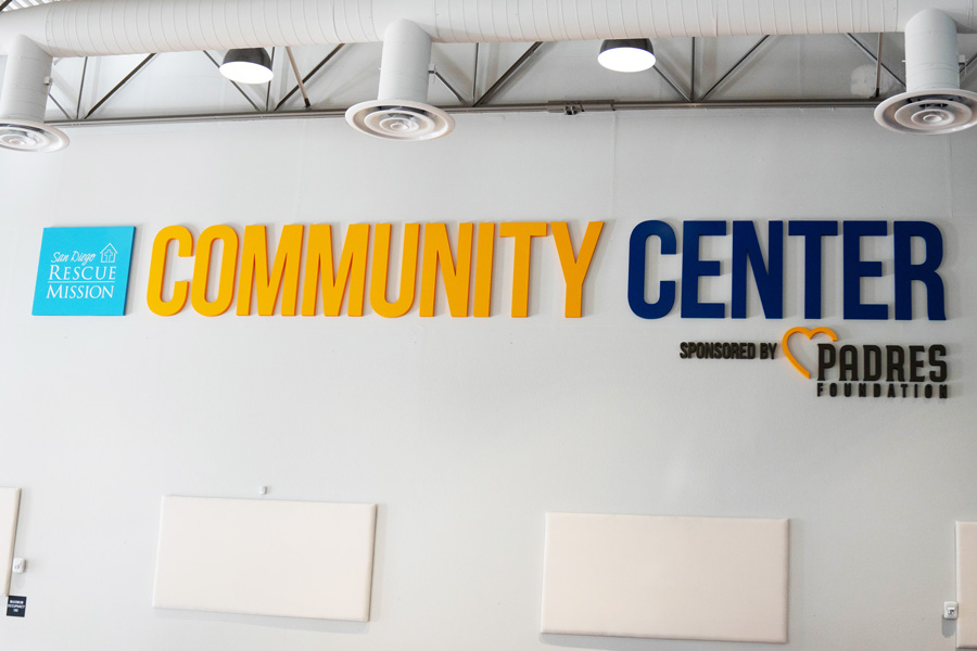 Community Center yellow and teal lettering on white wall